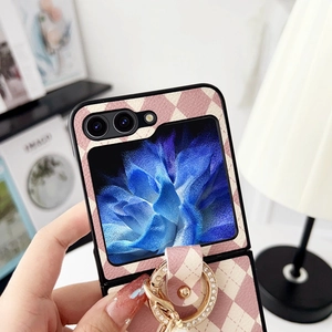Détail d'étui en cuir matelassé beige avec anneau diamanté doré pour téléphone pliable