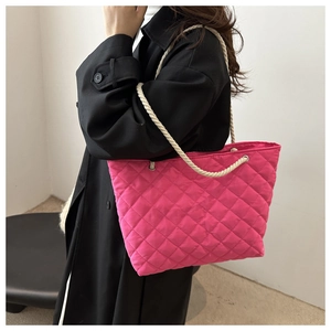 Modèle portant un sac cabas matelassé rose vif avec des poignées en corde épaisse