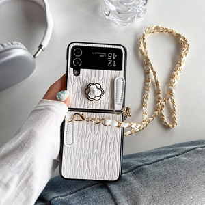 Detail of white wavy leather phone case with camellia flower and pearl strap