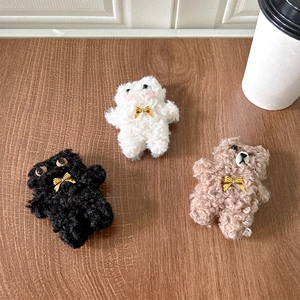 Detail of plush bear phone grips with golden bowknot charms in black, white and brown