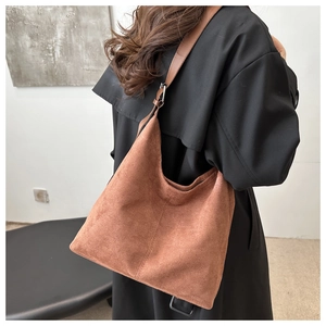 Detail of brown suede hobo bag with adjustable strap and silver metal hardware