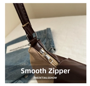 Detail shot of smooth silver zipper on brown and khaki patchwork tote bag