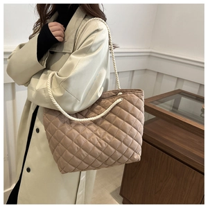 Detail of khaki quilted tote bag featuring a diamond pattern and white rope handle