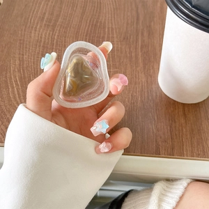 Close-up of a resin heart phone grip with glitter and marble inlay on a wooden table