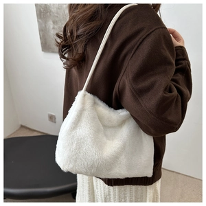 Détail du sac cabas blanc en fausse fourrure montrant la texture douce et la bandoulière