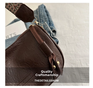 Detail of dark brown leather pillow bag featuring fashion embossing and a retro woven strap