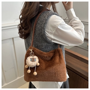 Détail d'un sac cabas marron en peluche avec un pendentif mouton et texture fausse fourrure