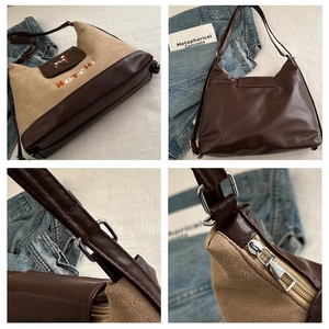 Detail view of silver metal buckles, zipper, and dog embroidery on suede tote bag