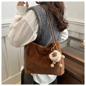 Detail of caramel plush tote bag with faux fur texture and cute sheep charm accessory