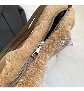 Detailed close-up of smooth silver metal zipper on khaki faux fur tote shoulder bag