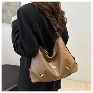 Dettaglio borsa hobo marrone con decorazioni a farfalla in metallo dorato tridimensionale