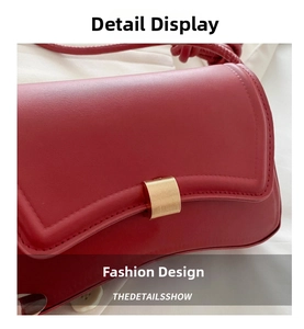 Macro shot of red leather shoulder bag with textured gold clasp and fine stitching