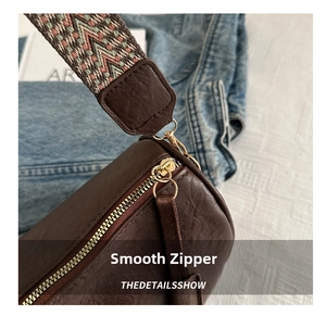 Close-up of retro brown barrel bag with lychee texture and woven shoulder strap