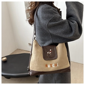 Detail of faux suede backpack showing the beige canvas and dark brown leather stitching