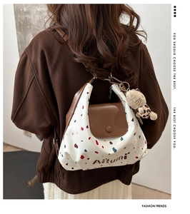 Borsa tote a pois con manici in pelle marrone e ciondolo a forma di orso sulla modella