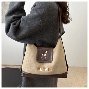 Close-up of the vintage tote bag with Mutehi puppy embroidery and leather trim detailing