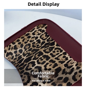 Détail macro de fausse fourrure léopard cousue avec du cuir bordeaux sur un sac seau