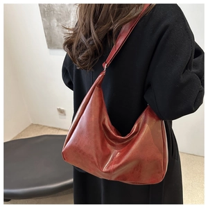 Close-up of dark red hobo bag showing oil-waxed PU leather texture and crescent shape