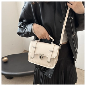 Dettaglio della borsa in pelle bianco crema con chiusura argento e tracolla regolabile