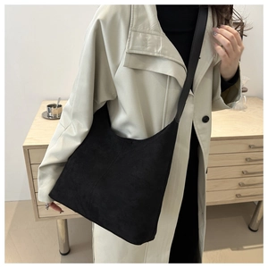 Detailed view of a vintage black suede hobo tote bag worn on shoulder for commute