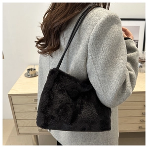 Détail du sac fourre-tout en peluche noire douce avec de fines lanières de cuir à l'épaule