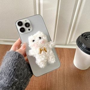 Detailed view of soft 3D plush bear on a light gray phone case with golden bow accessory