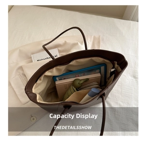 Top view of spacious dark brown tote bag interior with multiple everyday items