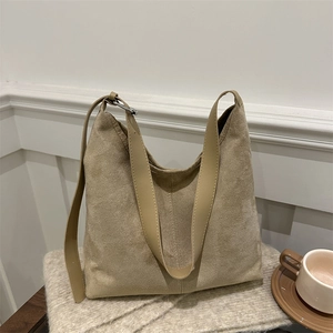 Minimalist khaki hobo tote bag in suede texture with adjustable strap on knit fabric