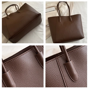 Detail view of dark brown lychee leather texture and stitching on large tote bag