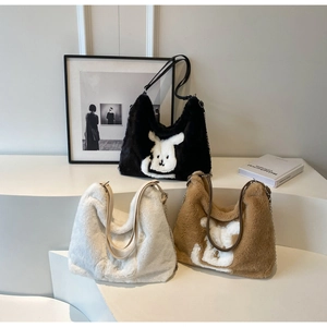 Detail of plush tote bag with cartoon rabbit patch and stylish metal chain strap
