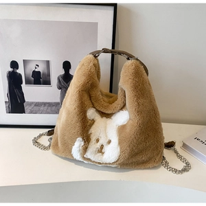 Close-up of brown plush tote bag with white rabbit motif and metal chain strap