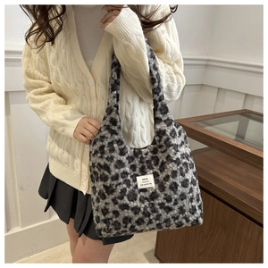 Detail of plush leopard print tote bag with white woven label on winter fuzzy material
