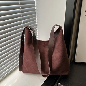 Retro brown suede tote bag for women with adjustable leather strap in natural lighting