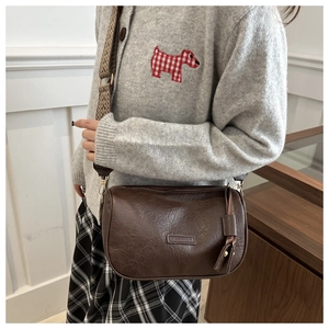 Detail of dark brown Boston bag featuring vintage oil wax texture and wide shoulder strap