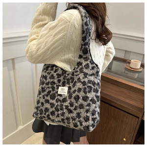 Close-up of plush leopard print faux fur texture and woven label on large tote bag