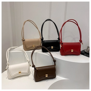 Minimalist baguette shoulder bags in five colors with gold buckles on a white stand