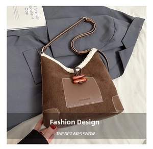 Detail of plush corduroy bucket bag with faux shearling trim and wooden toggle closure