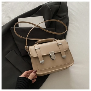 Close-up of beige vintage crossbody bag with silver buckle lock and PU leather texture