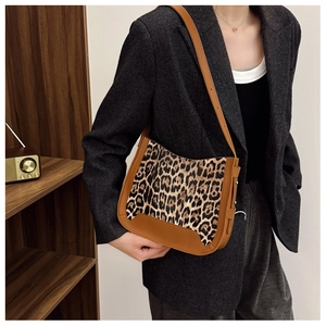 Detailed view of leopard print faux suede bucket bag with brown leather side stitching