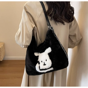 Detail showing plush black tote bag with white puppy motif and silver chain strap