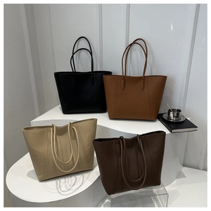 Minimalist large-capacity tote bags in four colors on a white geometric stage