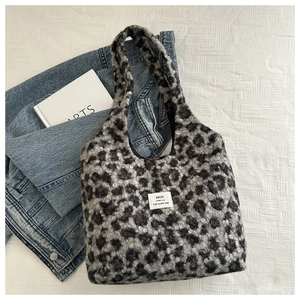 Macro view of leopard print plush tote bag showing soft texture and HOU brand label