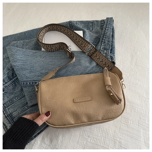 Close-up of khaki retro shoulder bag with wide geometric strap and FASHION embossed label