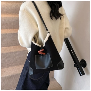 Detail of plush faux shearling lining and vintage horn buckle on black shoulder bag