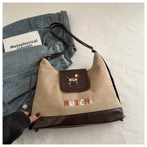 Detail view of suede large capacity backpack with dog embroidery and leather patchwork