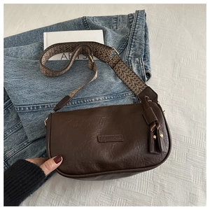 Close-up of brown saddle bag with ethnic pattern wide strap and leather tassels