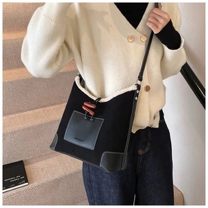 Detail view of contrast plush shoulder bag with toggle closure on a female model