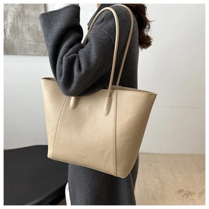 Close-up of beige pebble grain leather tote bag showing high-quality texture and embossing