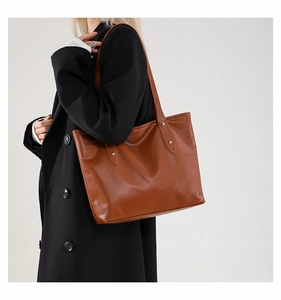 Dettaglio borsa tote marrone trama coccodrillo con borchie dorate e sottile tracolla