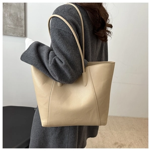Close-up of beige lychee grain leather tote bag featuring fashion text and soft texture